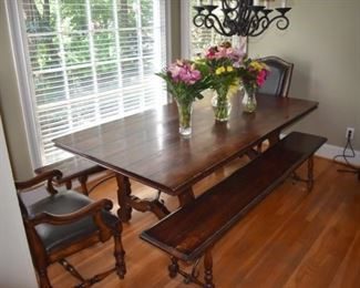 A dining room table with chairs and a bench