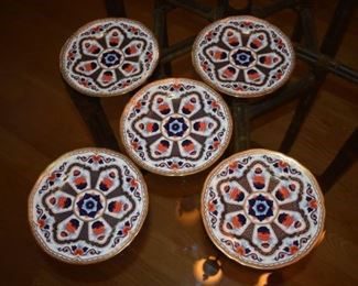 A set of five plates with a floral design.