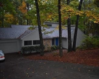A house in the woods with trees and leaves