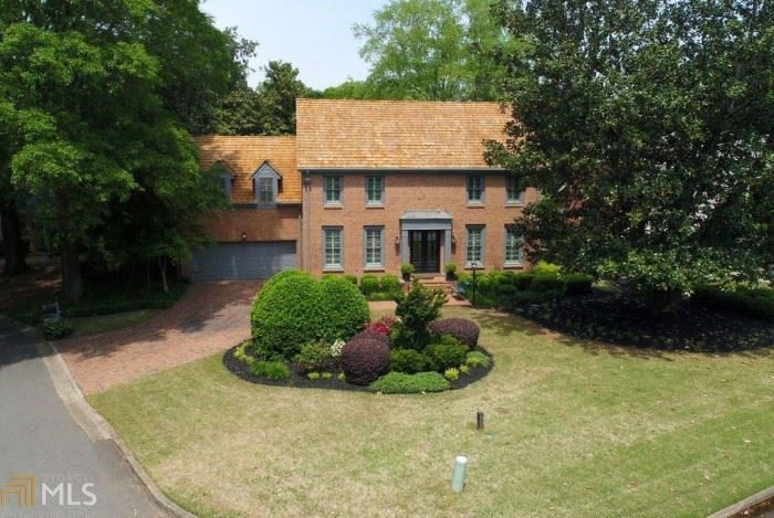 A large brick house with a garden in the front yard.