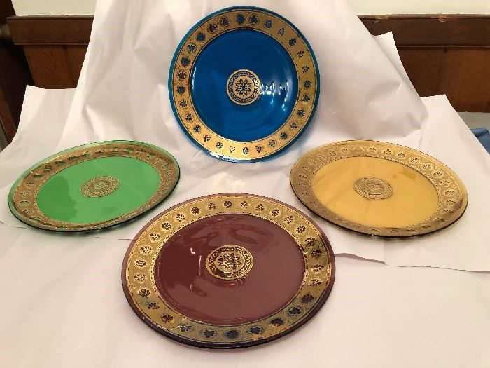 Four plates are sitting on a table with white paper.